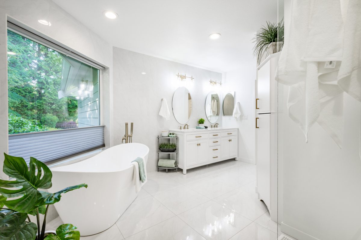 This home has large open concept room painted white with simple and stylish decor. The kitchen has expansive countertops and cupboards and cabinets with gold fixtures. Living room has wall mounted tv and an electric fireplace, the family room has 2 blue recliners and a wood burning fireplace. Rooms have multiple large windows with views to the garden and golf course beyond the backyard. Lush landscaping with mature trees. Bathroom is sparkling clean and white marble with free standing bath tub and open glass wall shower with gold fixtures.